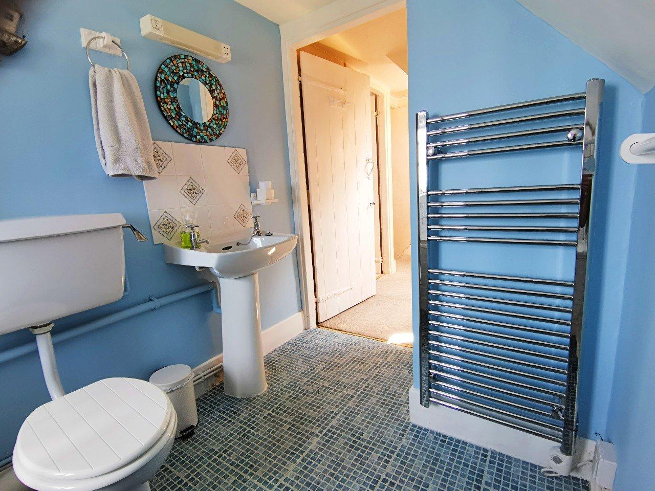 Family bathroom with shower and heated towel rail.