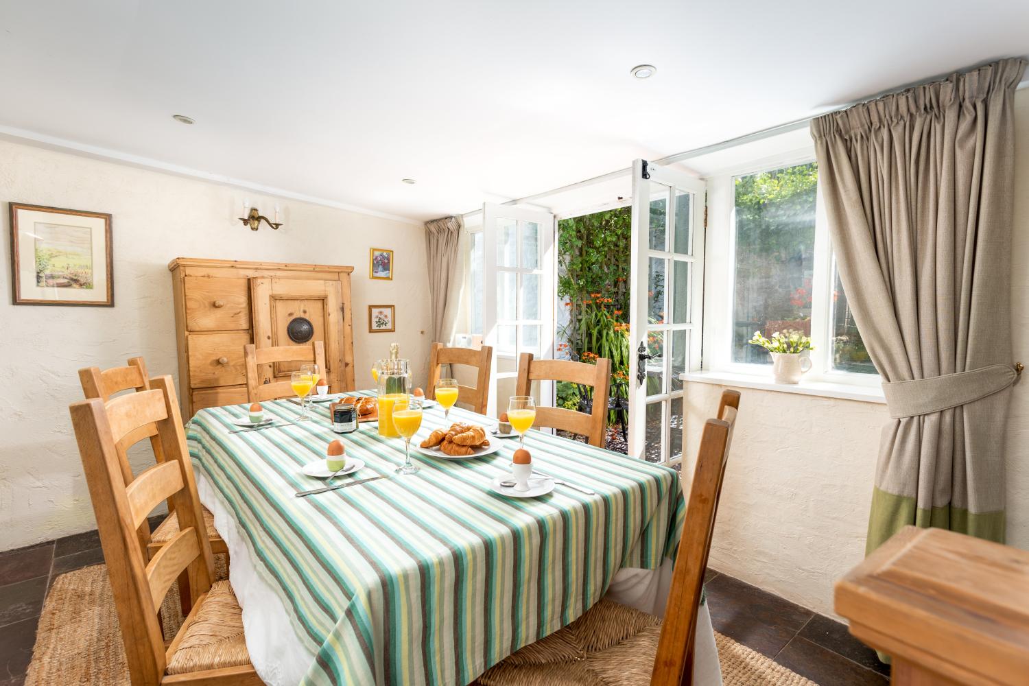 There's a large dining table in a room which opens onto the courtyard.