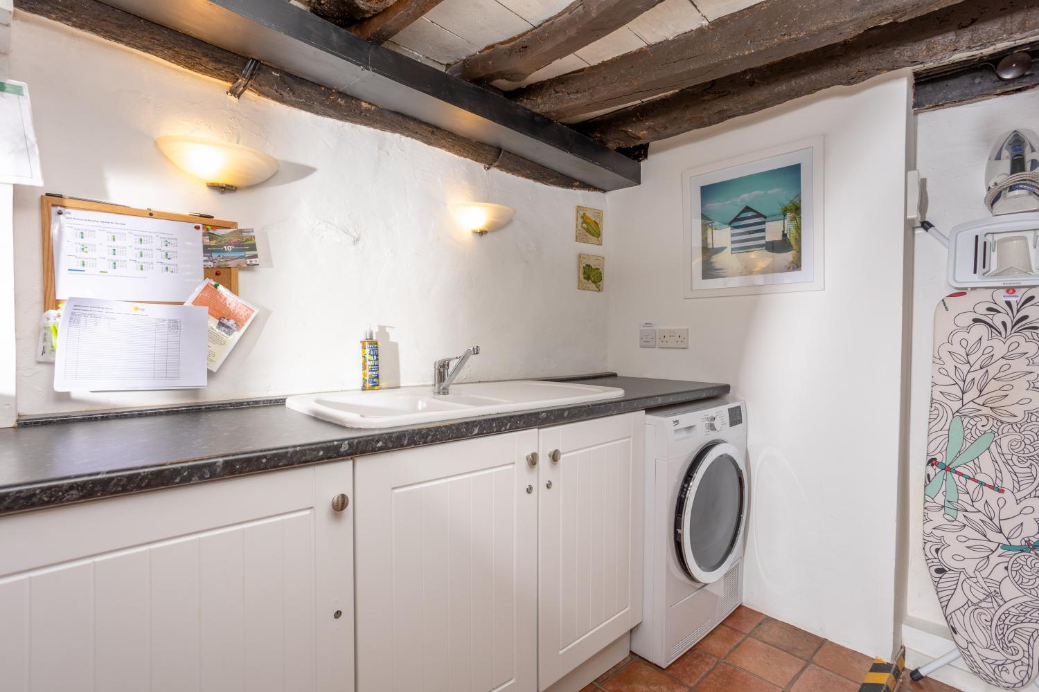 The utility room has a tumble drier, iron and ironing board and WC