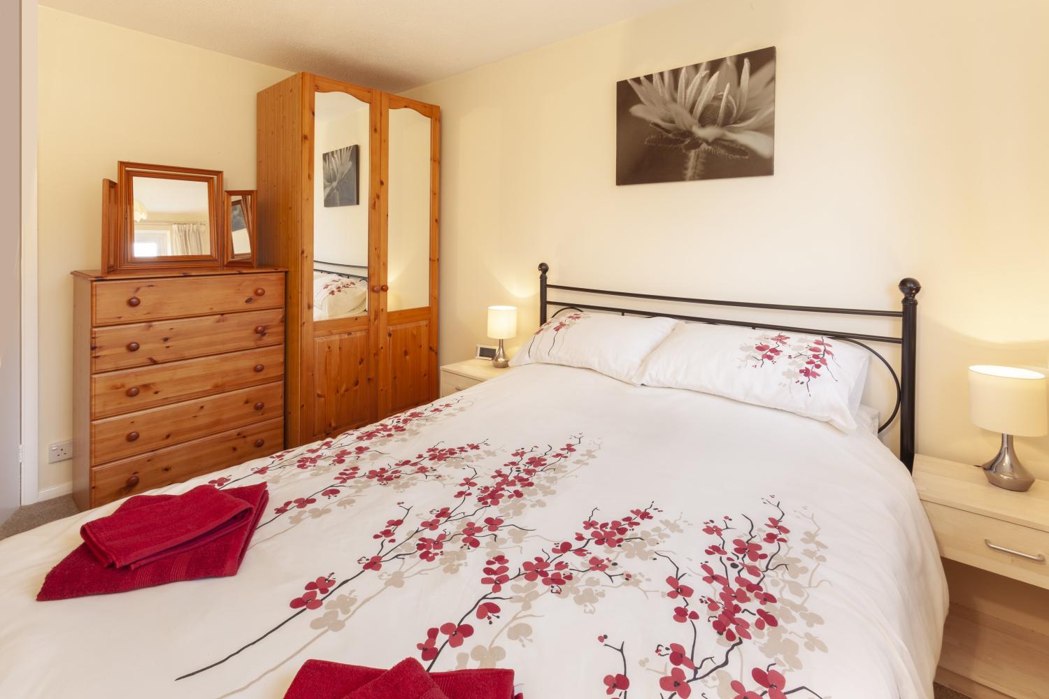 Bedroom 1, King-sized bed, chest of drawers and double mirrored wardrobe