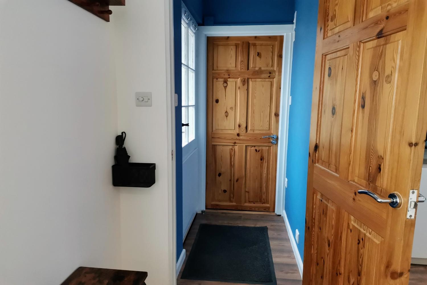 Front door into hallway leading living area, kitchenette and bathroom (shower only)