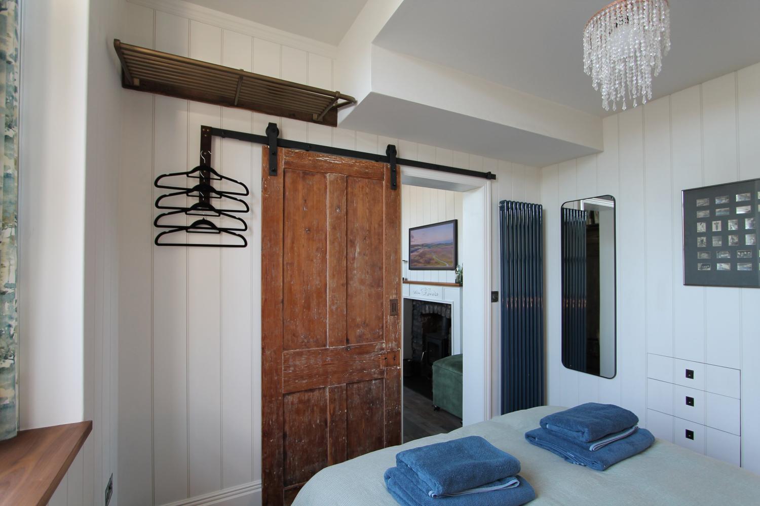 The ground floor bedroom showing sliding door and hanging space